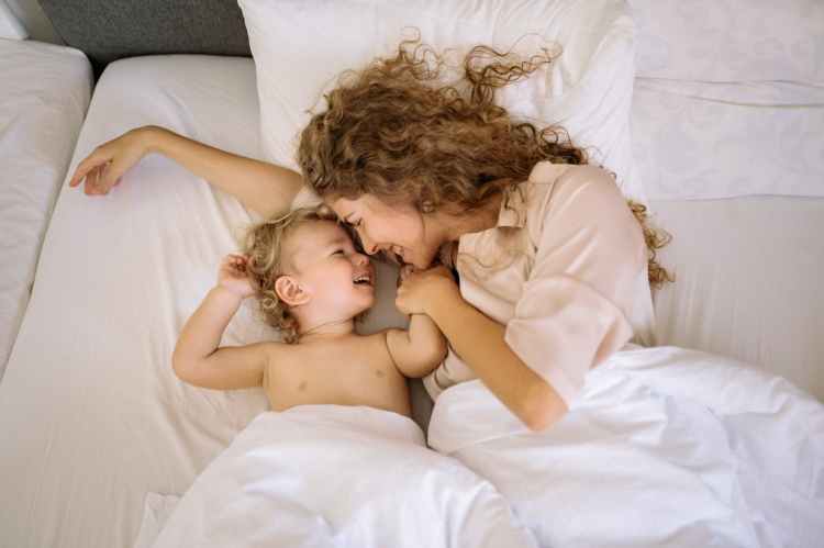 a woman and kid on the bed